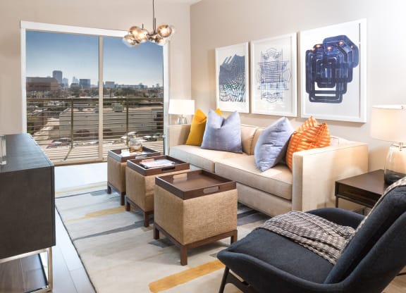 model living room with couch and a big window at Knox Heights in Dallas, TX