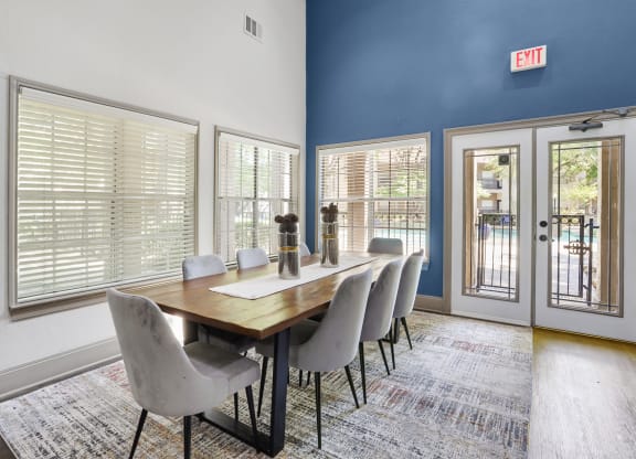 a dining room with a long wooden table and white chairs