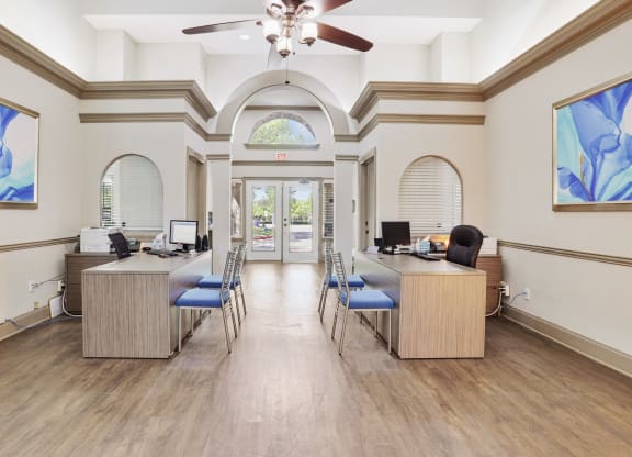 an office with two desks and a ceiling fan