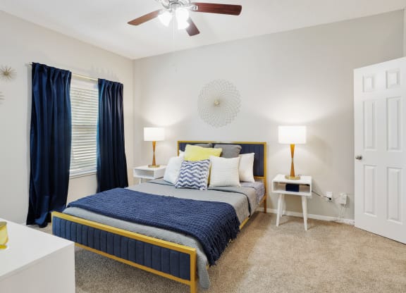 a bedroom with a bed and a ceiling fan
