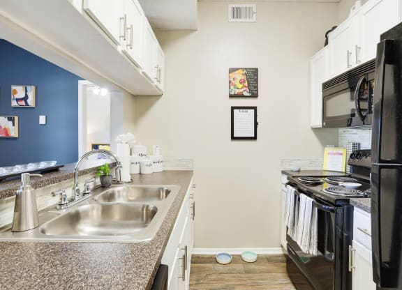 a kitchen with white cabinetry and black appliances