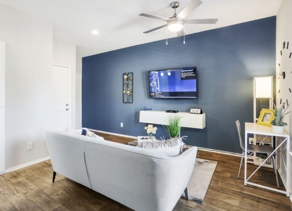a living room with a blue accent wall and a white couch