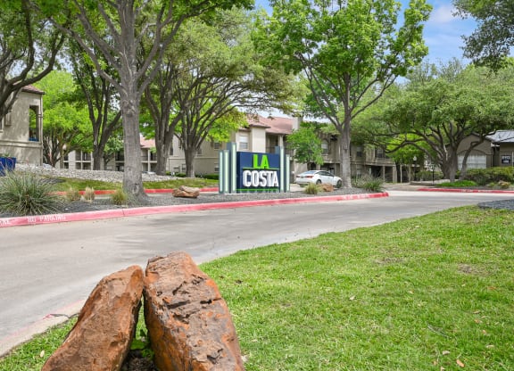 a tree that has been cut down in front of a sign that says la costa