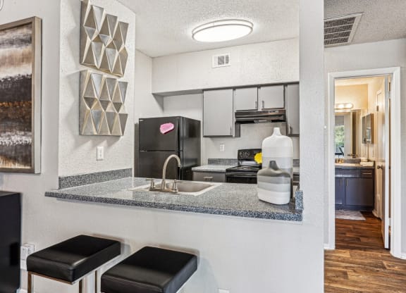 Modern kitchen with stainless steel appliances and a breakfast bar at Laurels of Sendera apartments in Arlington, TX