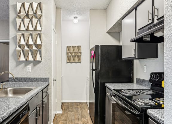 a kitchen with black appliances and granite counter tops