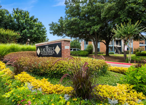 Property sign with an assortment of flowers and greenery at Laurels of Sendera in Arlington TX