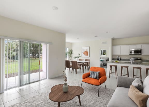 a living room and kitchen with a sliding glass door
