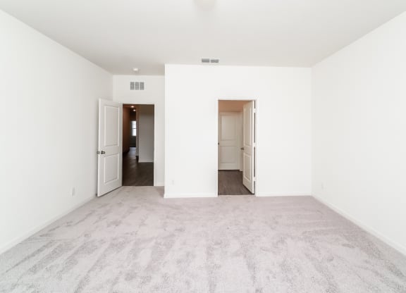 a bedroom with white walls and carpet