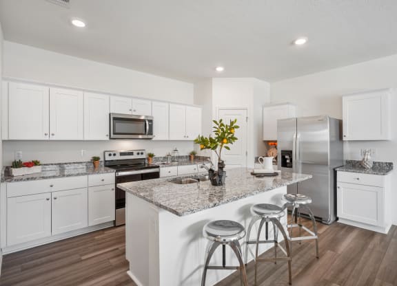 Maple open kitchen with island, granite counter tops, and stainless steel appliances at Beacon at Ashley River Landing in Summerville, SC