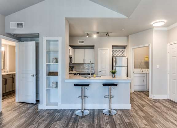 A2 model kitchen and dining area with stainless steel appliances at Asheville at Spring Branch apartments in Houston, TX