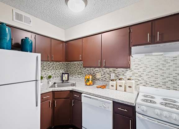 A kitchen with brown cabinets and a white refrigerator.