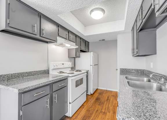 A kitchen with white appliances and a granite counter top.