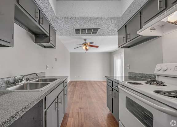 A modern kitchen with a stainless steel sink and stove.