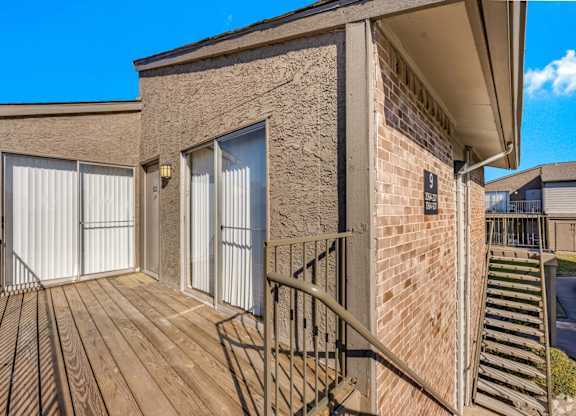 A second-floor apartment building deck at Montfort Crossing Apartments in Dallas, TX.