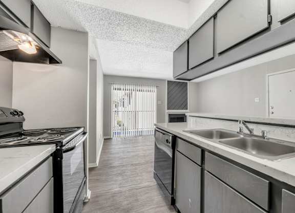 A kitchen with a stove top oven and a sink.
