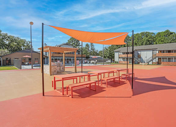 Picnic benches and a communal barbeque in a paved area at The Marq in Shreveport, LA