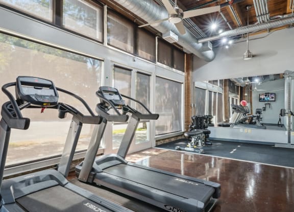 Murray Building gym with cardio equipment, free weights, and multi-use cable machine | Deep Ellum Lofts in Dallas, TX