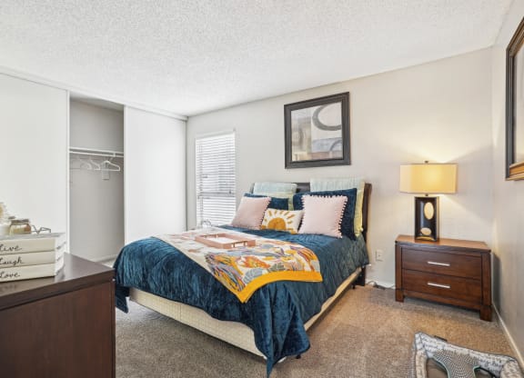 Model A2 floor plan bedroom with a bed, dresser, window Noel on The Parkway in Dallas, TX