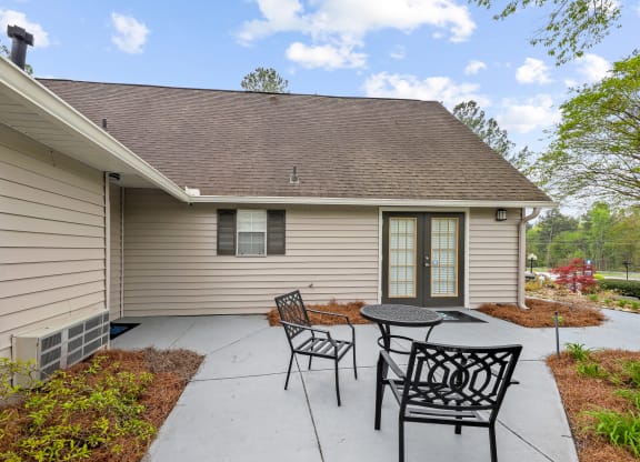 a patio with a table and chairs in front of a house