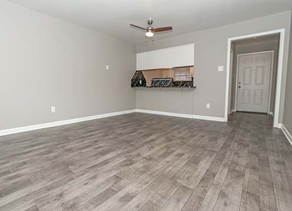 A living room with a ceiling fan and foyer at Orleans Square in Shreveport, LA