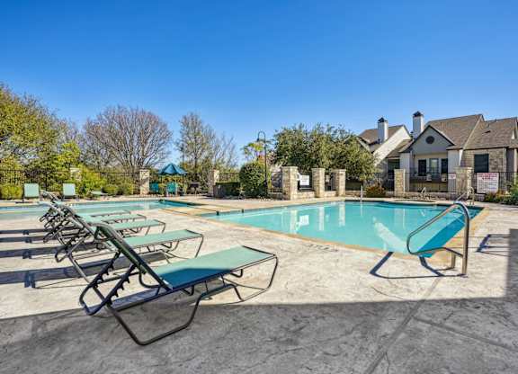Shot of our pool with lounge chairs at On the Green apartments in Austin, TX