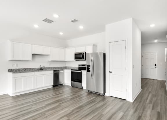 a kitchen with white cabinets and stainless steel appliances