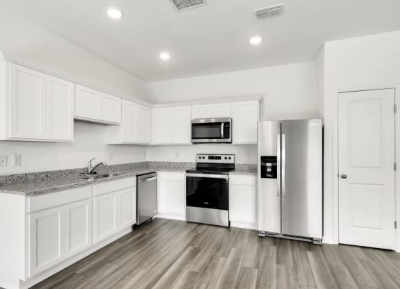 a kitchen with white cabinets and stainless steel appliances