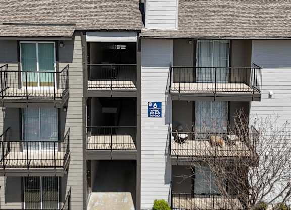 An apartment building with private balconies at The Park on Preston Apartments in Dallas, TX