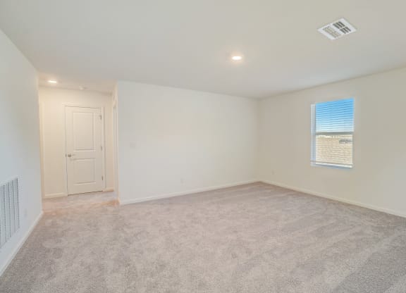 an empty living room with white walls and a window