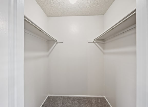 a walk in closet in a bedroom with white walls and a white ceiling