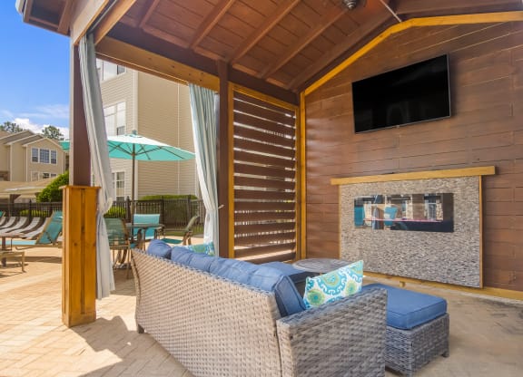 Comfortable sitting area by the pool with a relaxing couch at Angel Landing apartments in Pensacola, FL