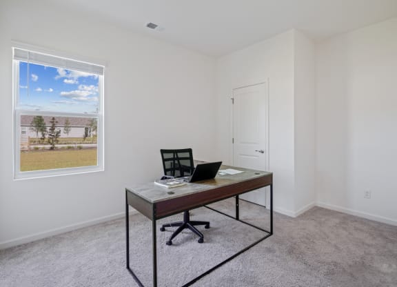 a home office with a desk and a window