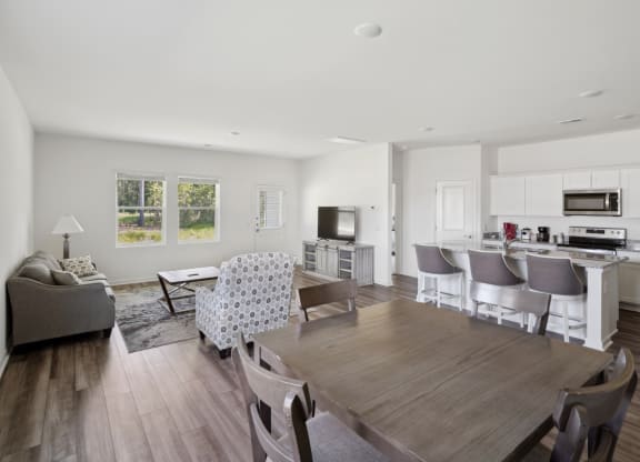 a living room with a dining room table and a kitchen
