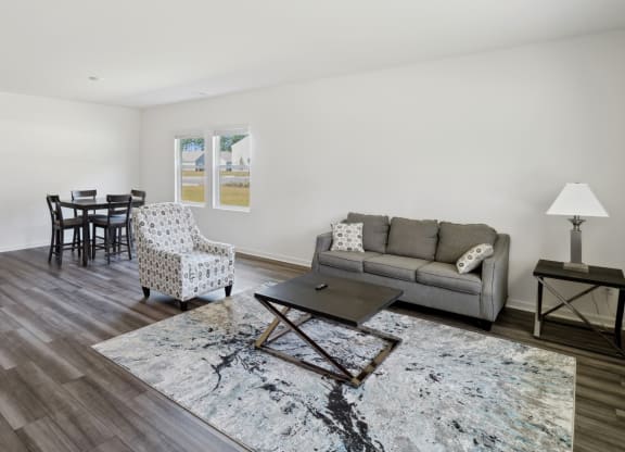 a living room with a couch and chairs and a dining room table