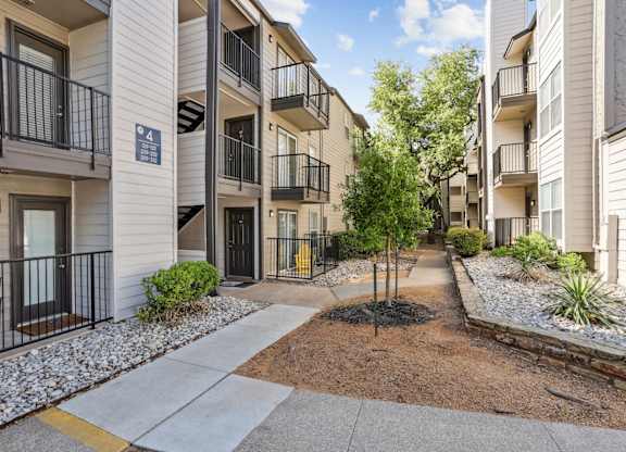 Apartment complex with a tree in the middle of the courtyard.