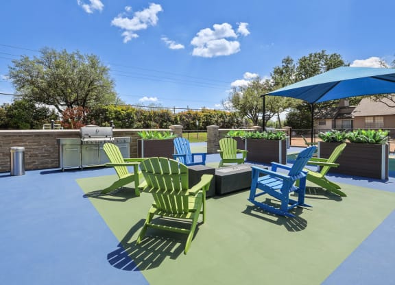 a patio with green and blue chairs and a bbq grill