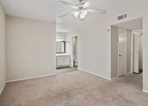 an empty bedroom with a ceiling fan