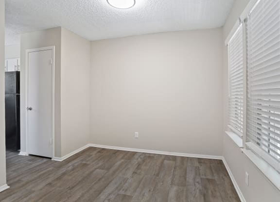 a bedroom with hardwood floors and a large window