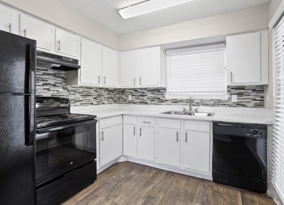 a kitchen with white cabinets and black appliances