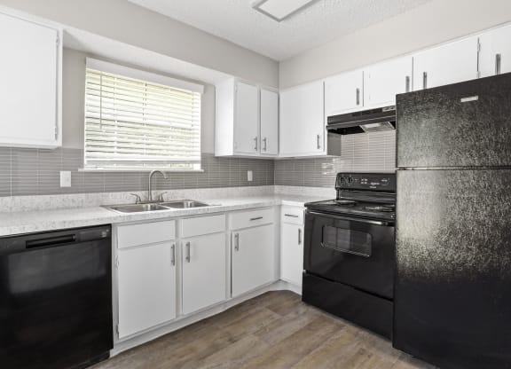 a kitchen with white cabinets and black appliances