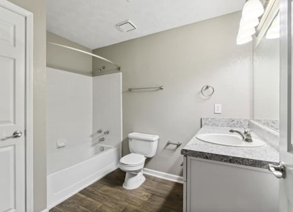 Bathroom with a toilet, sink and a bath tub at Oakley Run apartments in Smyrna, GA