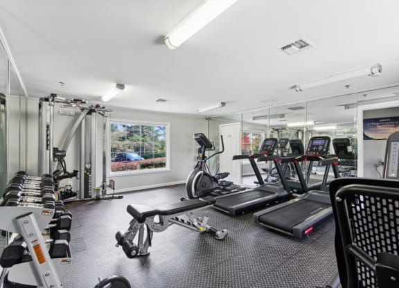 Fitness center equipped with cardio equipment and weights at Oakley Run apartments in Smyrna, GA