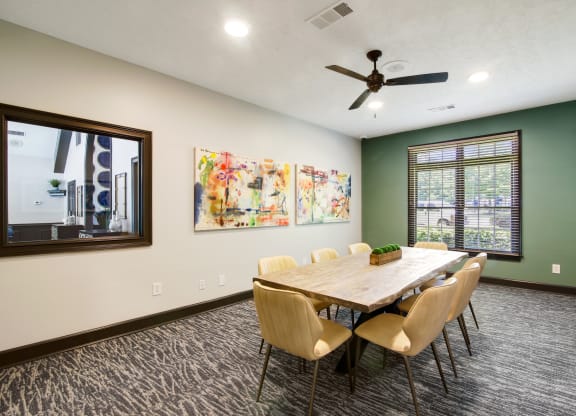 a conference room with a table and chairs and a ceiling fan at Grand Reserve at Columbus Apartments in Columbus, Georgia, GA