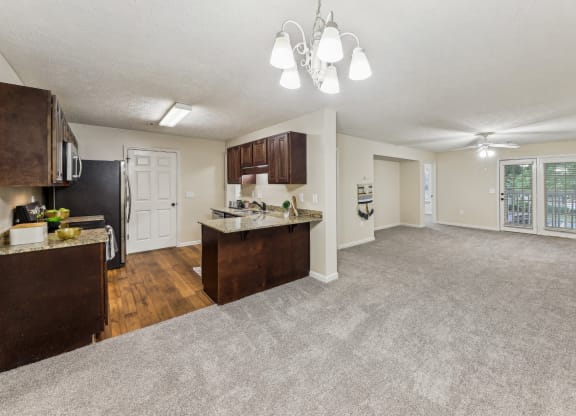 an open living room and kitchen with a carpeted floor  at Grand Reserve Columbus in Columbus, GA