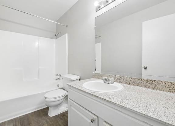 Second bathroom with a toilet, sink, and mirror in C2b floor plan at Riverwood Crossing apartments in Roswell, GA.