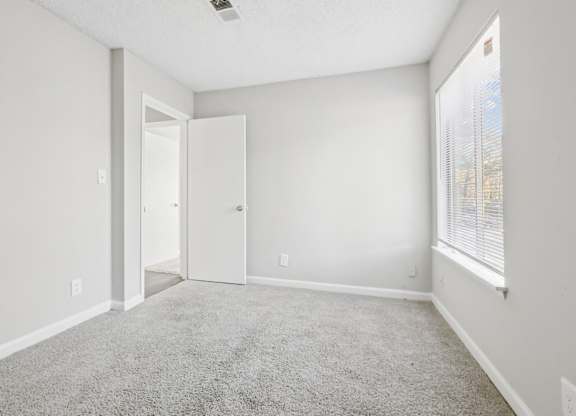 Third bedroom view of entrance with carpet flooring in C2b floor plan at Riverwood Crossing apartments in Roswell, GA.