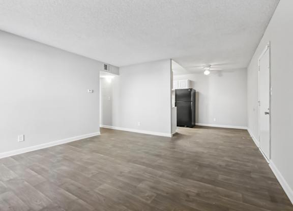 Living room shot looking toward kitchen and dining area with vinyl wood flooring in B1 floor plan at Riverwood Crossing apartments in Roswell, GA.