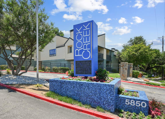 a blue sign with white letters in front of a building
