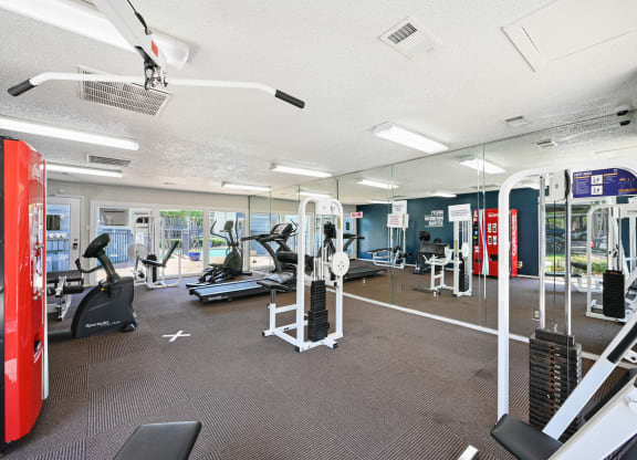 a spacious fitness center with cardio machines and other exercise equipment