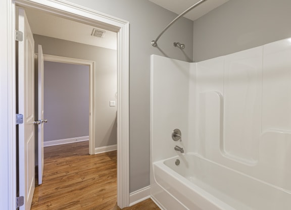 a bathroom with a tub and a shower and a door